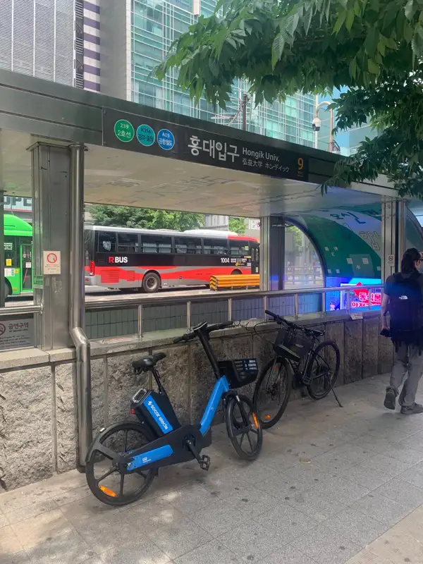 Eingang der U-Bahn-Station Hongik University (Hongdae) – Linie 2, Airport Express und Gyeongui-Jungang, mit Leihrädern davor