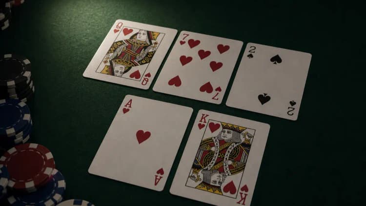 As-rey de corazones con un flop de reina-siete de corazones sobre el tapete verde, un proyecto de color de nueve outs ligado en el flop junto a una torre corta de fichas