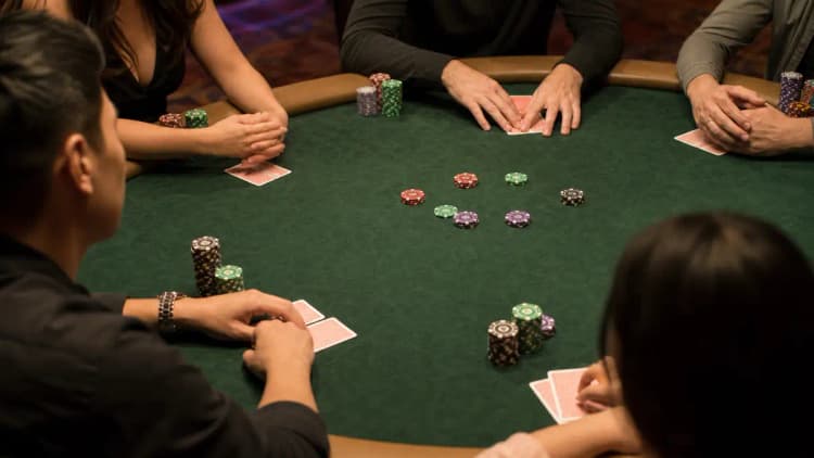Mehrere Spieler sind in dieselbe Hand gelimpt, sodass mehrere kleine Chipstacks rund um den grünen Filz nach vorne geschoben in einem billigen Multiway-Pot liegen